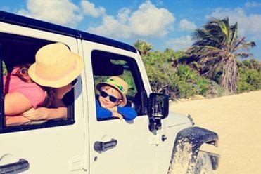 Family driving a jeep on the beach