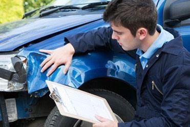 Mechanic inspecting damaged car