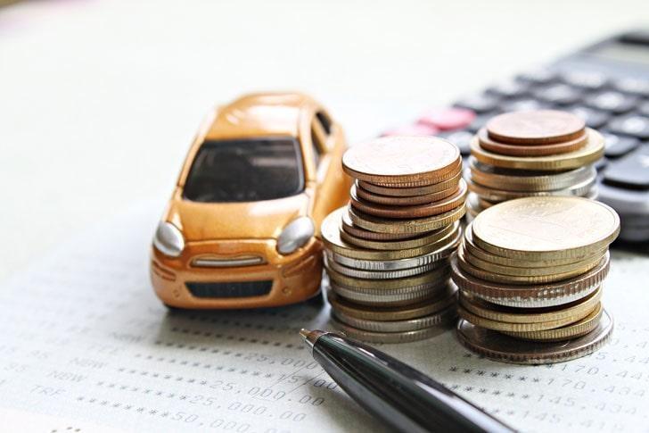 Miniature car model, coins stacked on desk