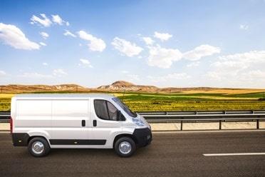 White van driving on road