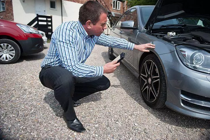 Businessman inspecting a rental car