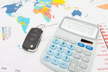 Calculator and car keys over world map