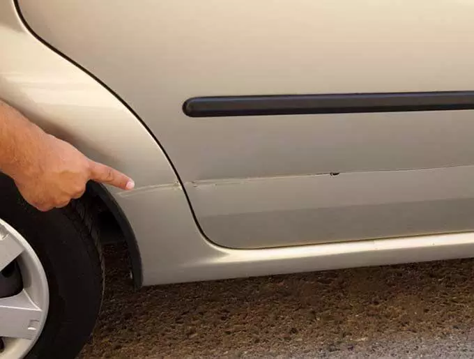 man pointing at car scratch