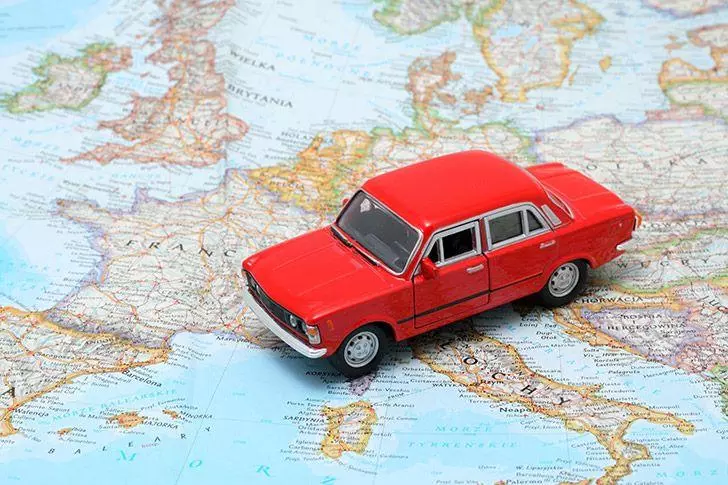 Toy car driving over map of Europe