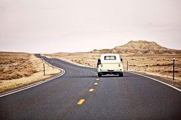 Car driving on long american stretch of road 