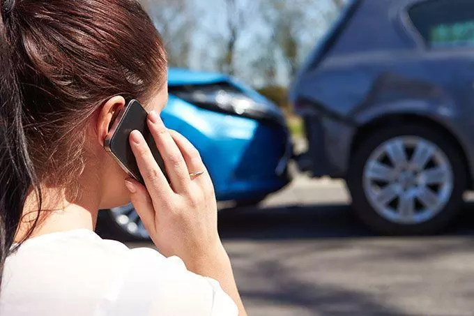Woman calling insurance company after car accident